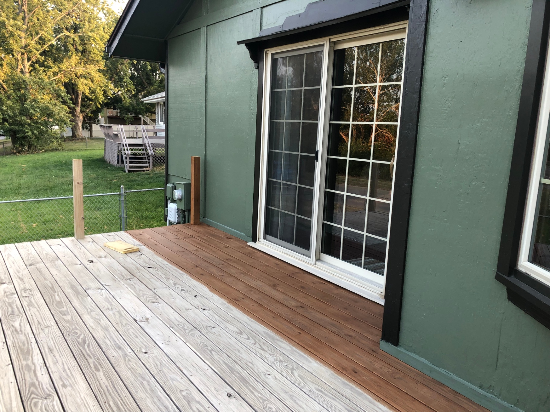 Deck boards mid-restain, showing Jake's careful staining work in progress